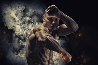 Professional boxer posing in the studio. He stands in front of the camera and elbows. The concept of sport