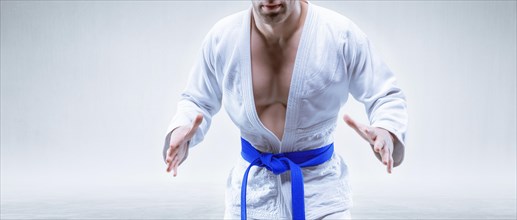 Sportsman in a kimono with a blue belt. The concept of karate and judo competitions.
