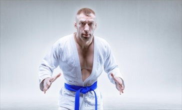 Sportsman in a kimono with a blue belt. The concept of karate and judo competitions.