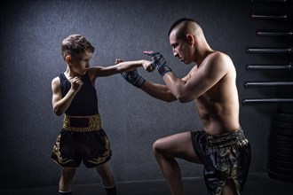 Kickboxing coach is training the boy. The concept of family
