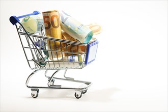 Shopping cart full of rolled up euro banknotes