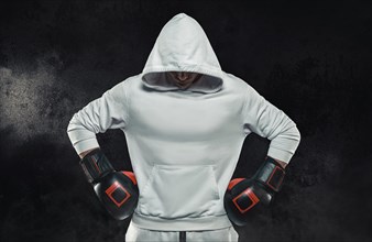 Brutal athlete stands in a white hoodie covered with a hood. Mixed martial arts concept. High image quality