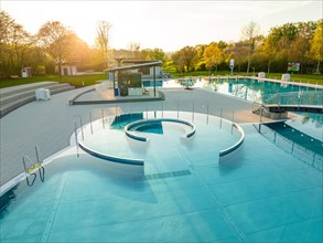 Overview of an empty outdoor pool with slide and sun-drenched pools