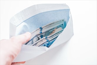 Pack of hundred-dollar bills lies in an envelope. The concept of bribery and corruption.
