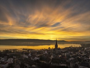 Aerial view of an atmospheric sunset over the old town centre of Radolfzell on Lake Constance with the cathedral tower