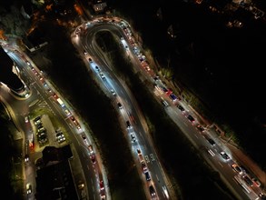 Nocturnal traffic scene with streaking lights of cars on a road bend