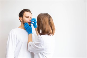 Doctor examines allergic swelling on the patient's lip