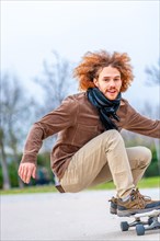 Vertical photo with copy space of a happy young man skateboarding in a park