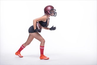 Woman in the uniform of an American football team player prepares to run with the ball. White background. Sports concept.