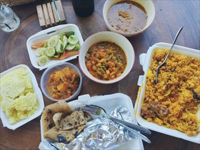 Colorful array of Indian food in takeout containers