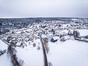 Aerial view of a village covered with snow in cloudy weather