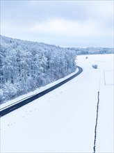 A road runs through a snow-covered landscape