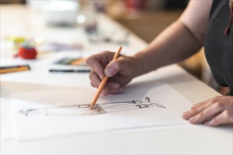 Close-up of a fashion designer drawing a fashion sketch