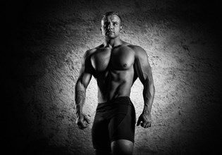 Portrait of a weightlifter who poses without a shirt. Front view
