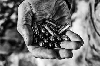 The fighter holds a handful of bullets in his palm for weapons.