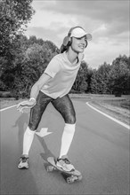 Image of a girl riding a skateboard in the park. Sports concept.