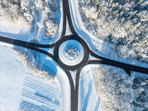 Aerial view of a snow-covered roundabout surrounded by wintry fields