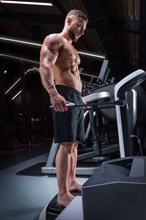 Muscular man stands on a special device to analyze the amount of body fat. Fitness concept.