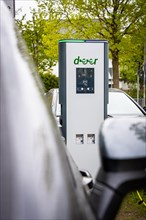 A modern electric vehicle charging station on a cloudy day in an urban environment