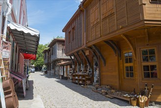 Cobbled street surrounded by shops with traditional wooden facades under a clear blue sky
