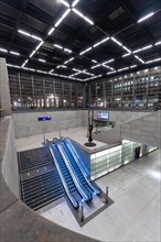 Modern railway station concourse with escalators and futuristic lighting