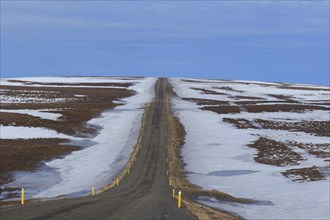 Road leading through the tundra towards the mountain range Lambafjoell