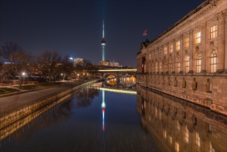 Nocturnal reflection of the television tower and a bridge in the water of a river
