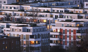 View in the evening at blue hour of high-rise buildings and apartment blocks with rental flats and condominiums in the Berlin district of Marzahn-Hellersdorf