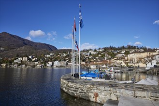 Harbour with flags and stone wall in Ascona