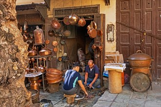 Moroccan coppersmiths working in workshop on Place Seffarine