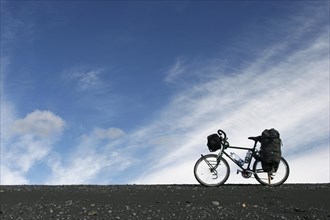 Heavily laden touring bicycle against blue sky