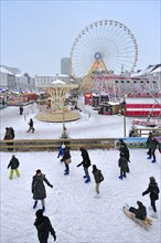 Ice skating rink and fun-fair in winter in the snow