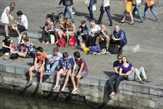 People enjoying the first spring sun by the waterside along the Graslei at Ghent