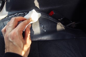The driver cleans the leather interior of the car