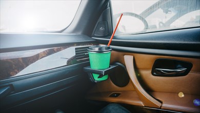 Cardboard cup of coffee inside a car