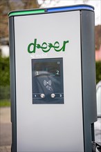 Close-up of an electric vehicle charging station with a clear sky in the background