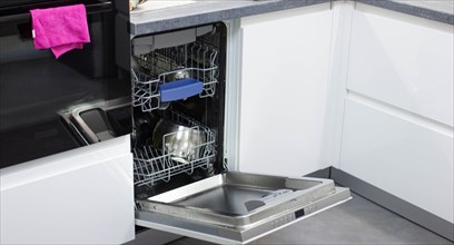 White modern dishwasher in the interior of a white kitchen