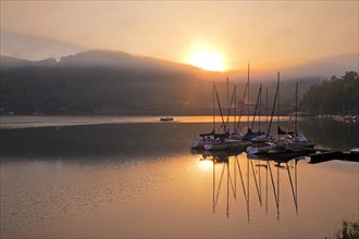 Sunrise over the Eder dam with dam wall and pleasure boats on the Edersee