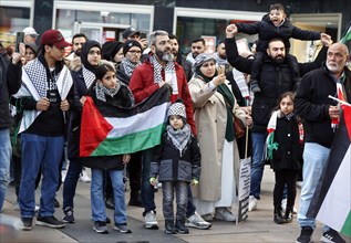 A family shows a Palestinian flag during the demonstration Freedom for the people of Gaza