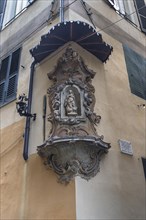 Sculpture of the Virgin Mary under a canopy on a corner house in the historic centre