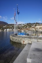 Harbour with flags and stone wall in Ascona