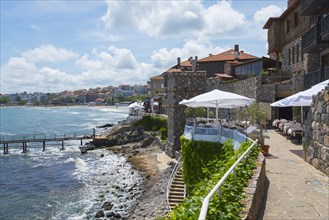 View of an idyllic coastal town with historic architecture and a terrace by the sea
