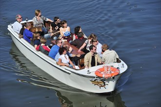 Tourists during sightseeing tour in boat on the river Lys