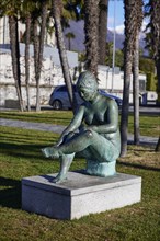 Sculpture of a seated female nude by sculptor Werner J. Mueller on the lakeside promenade of Lake Maggiore in Ascona