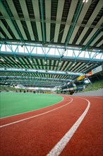 Interior view of a sports hall with running track and stands. Glass Palace
