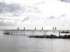People walking on the infinite bridge . The bridge is a work of art built for Sculpture by the Sea