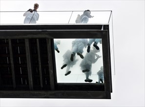 Visitors on the roof terrace of Salling department stores' standing on a glass window