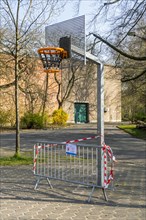Public basketball court at kids' playground closed and obstructed with barrier and tape due to the 2020 COVID-19