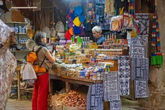 Western tourist buying souvenirs in gift shop in Souk el Henna in the old medina of the city Fes
