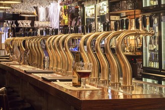 Bar counter showing array of Belgian draught beers served by taps in the Flemish cafe Rock Circus in the city Ghent